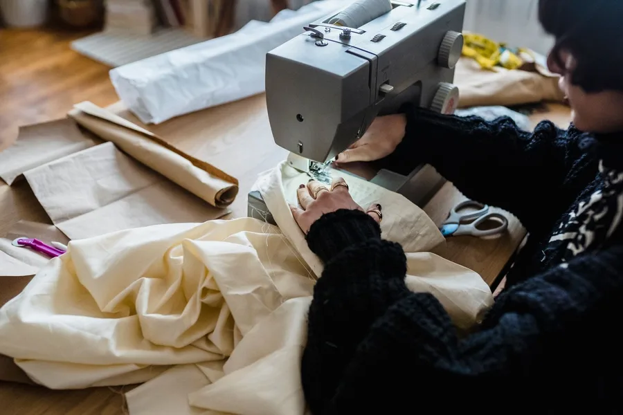 Fabric being stitched on a sewing machine in the workshop