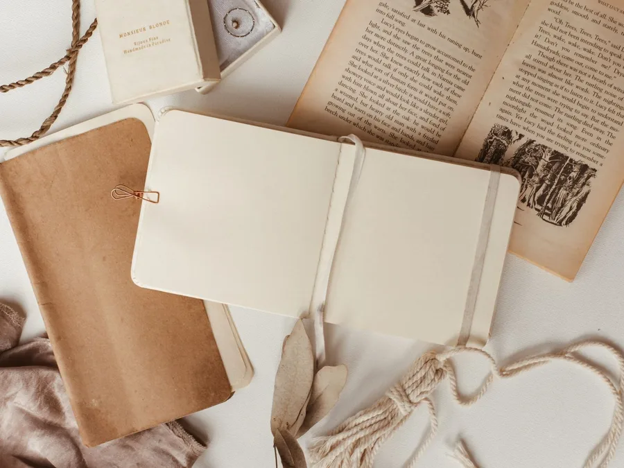 An open journal resting on the pages of an old book